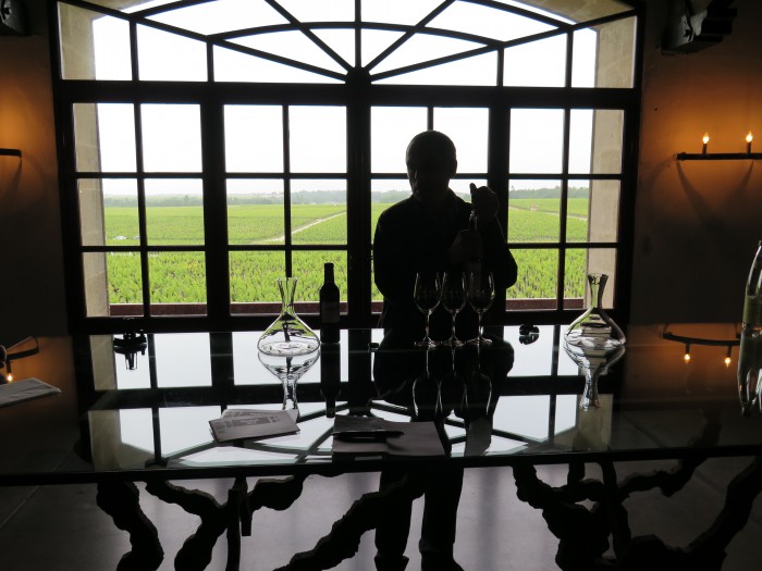 Radiant light casts dramatic shadows across Pontet Canet's tasting room as Jean Michel Comme, in silhouette, moves to pour the 2009 wine into a crystal decanter. Photo : Frank Ward.